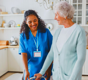 aide and senior woman smiling