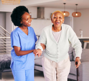 aide smiling while taking care the senior woman