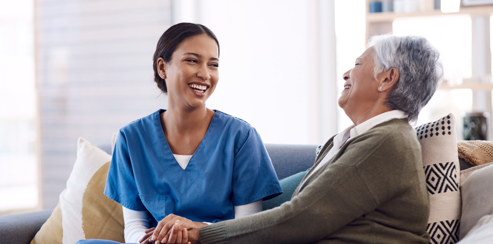 aide and senior woman laughing together