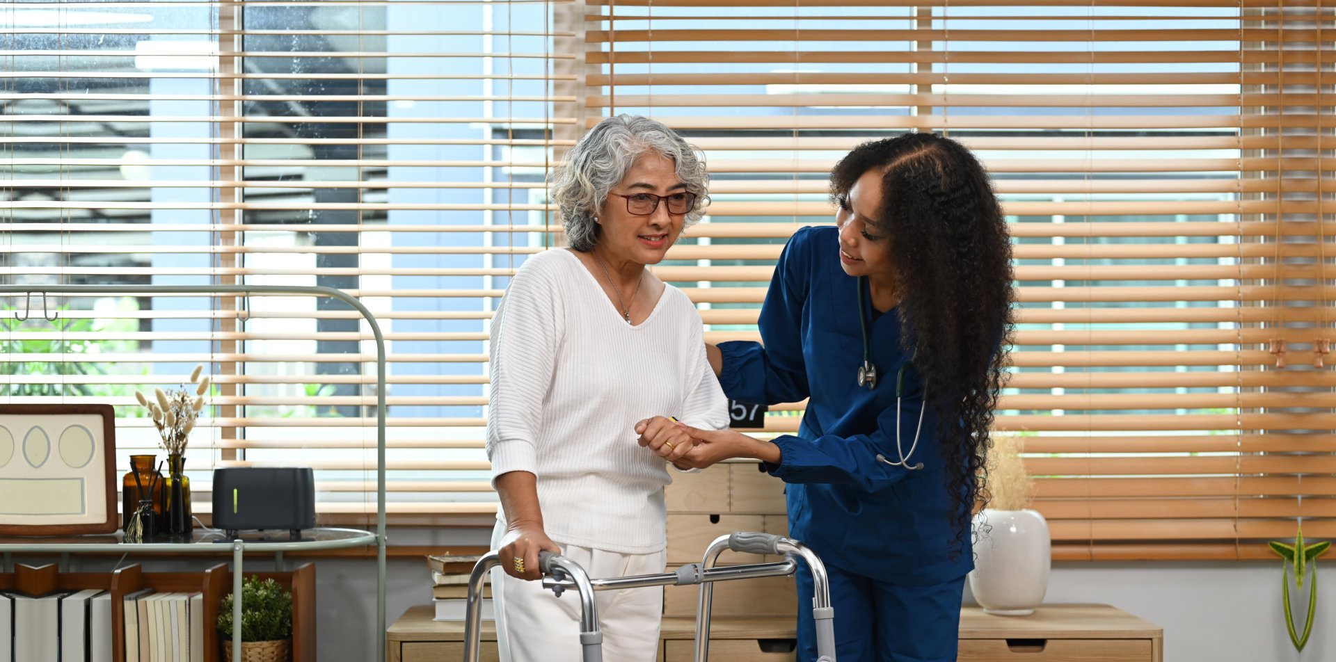 aide assisting the senior woman to walk