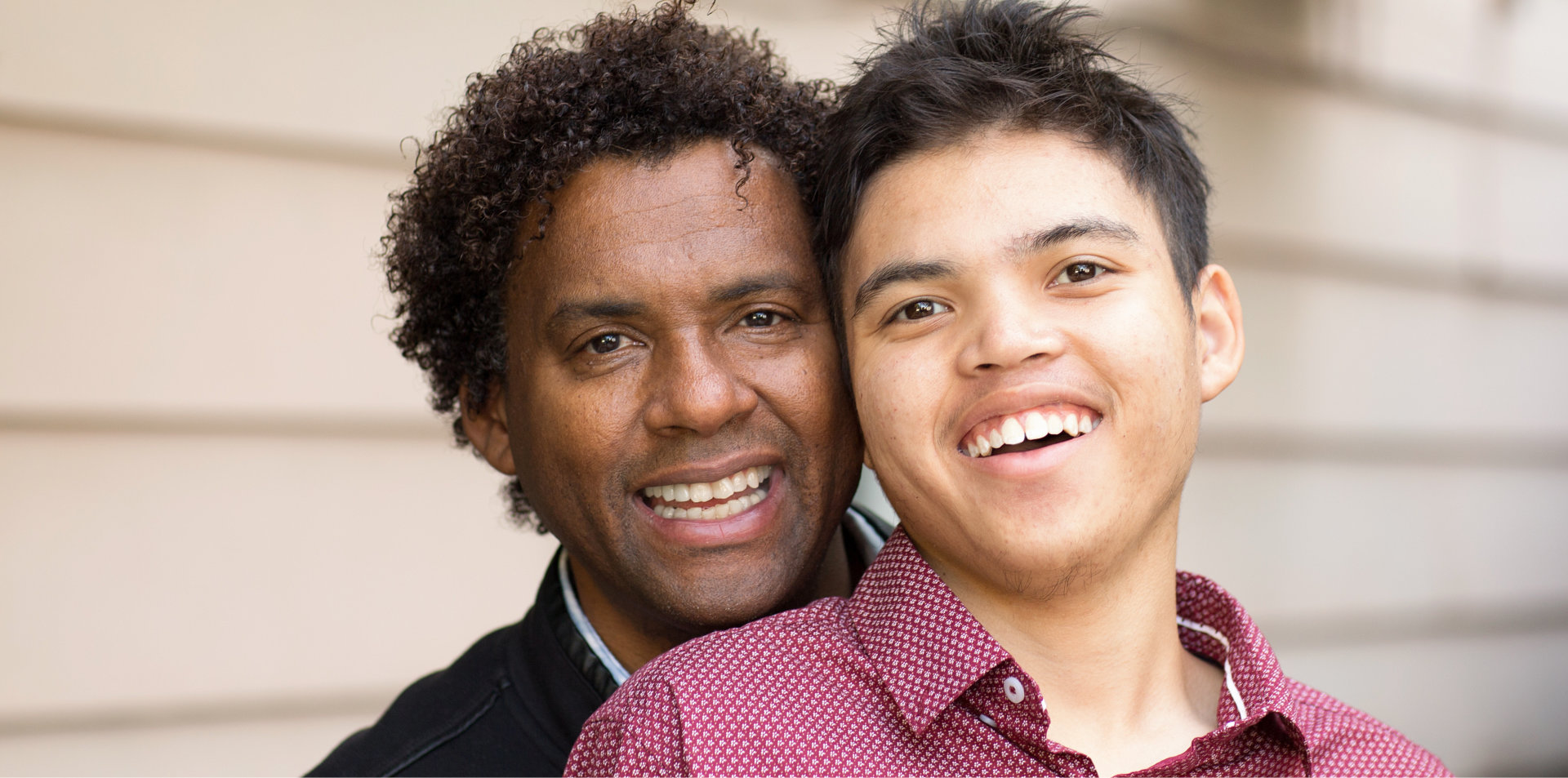 African American father hugging his son and smiling